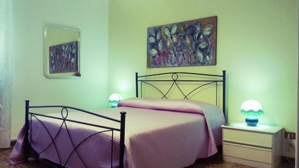 梅萨涅I Messapi的卧室配有一张床,墙上挂有绘画作品