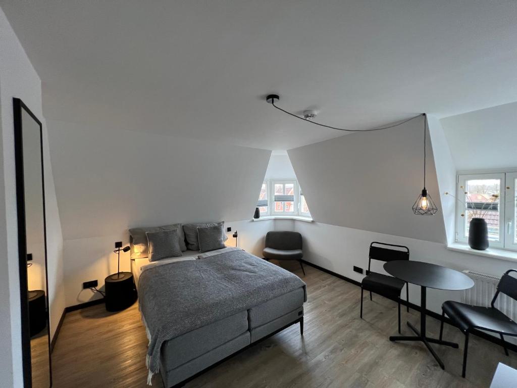 布克斯泰胡德Studiowohnung 6 in Buxtehude的卧室配有一张床和一张桌子及椅子