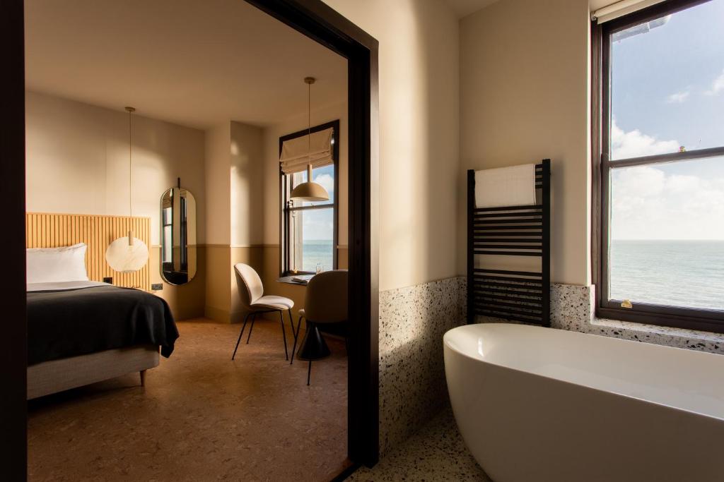 伊斯特布恩Port Hotel的带浴缸、床和窗户的浴室