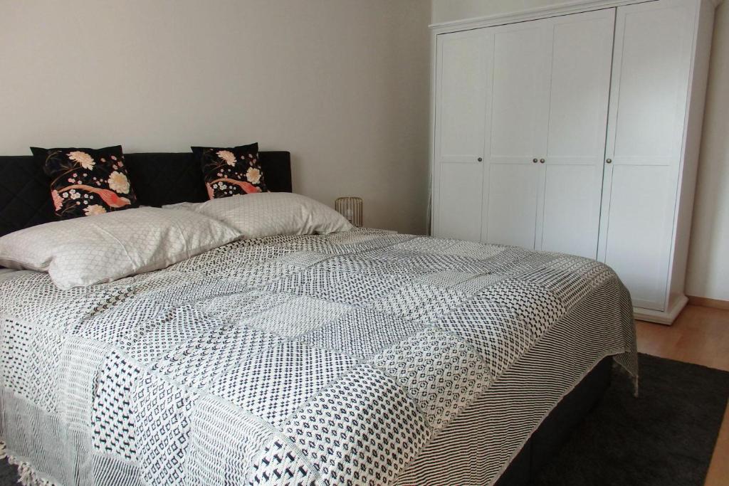 施塔特韦伦Ferienwohnung Bärensteinblick的一间卧室配有一张带黑白色棉被的床