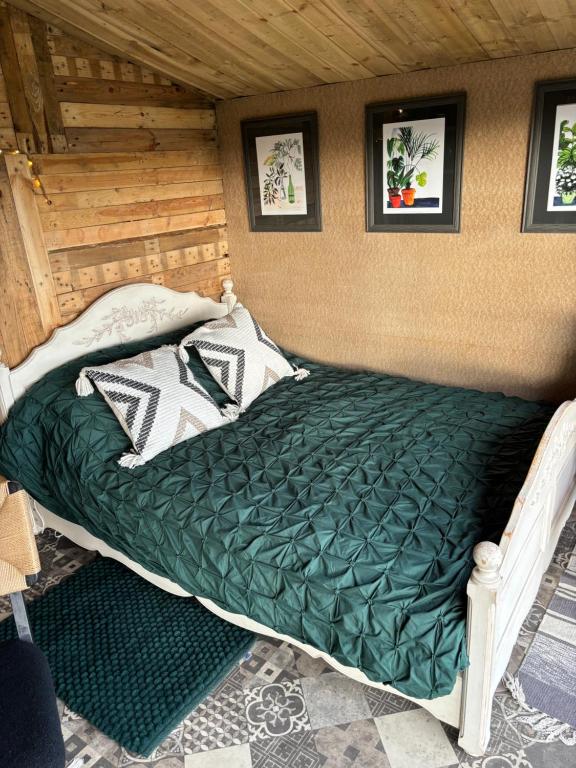 斯卡伯勒The Deer Hut at Carr House Farm的一张带绿色棉被的床