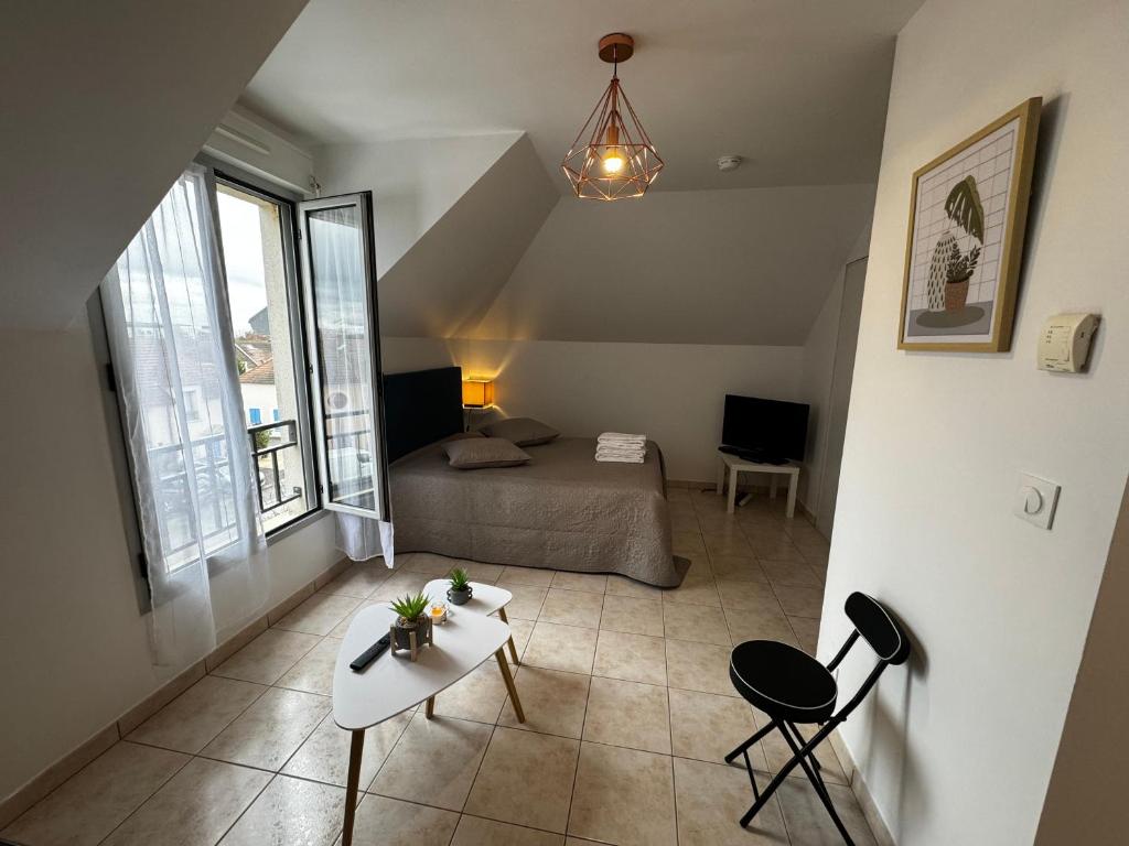 布西圣乔治Le studio du 72的卧室配有一张床和一张桌子及椅子