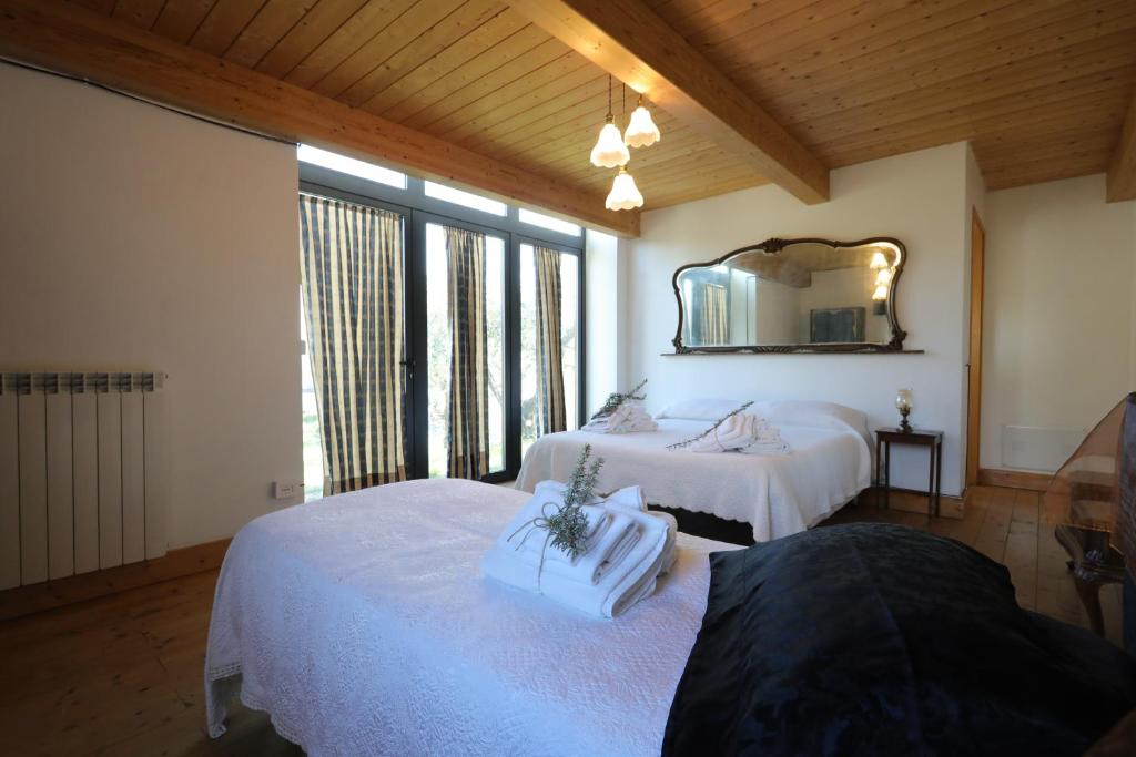 纳尔尼Agriturismo Madre Terra的一间卧室配有两张床和镜子