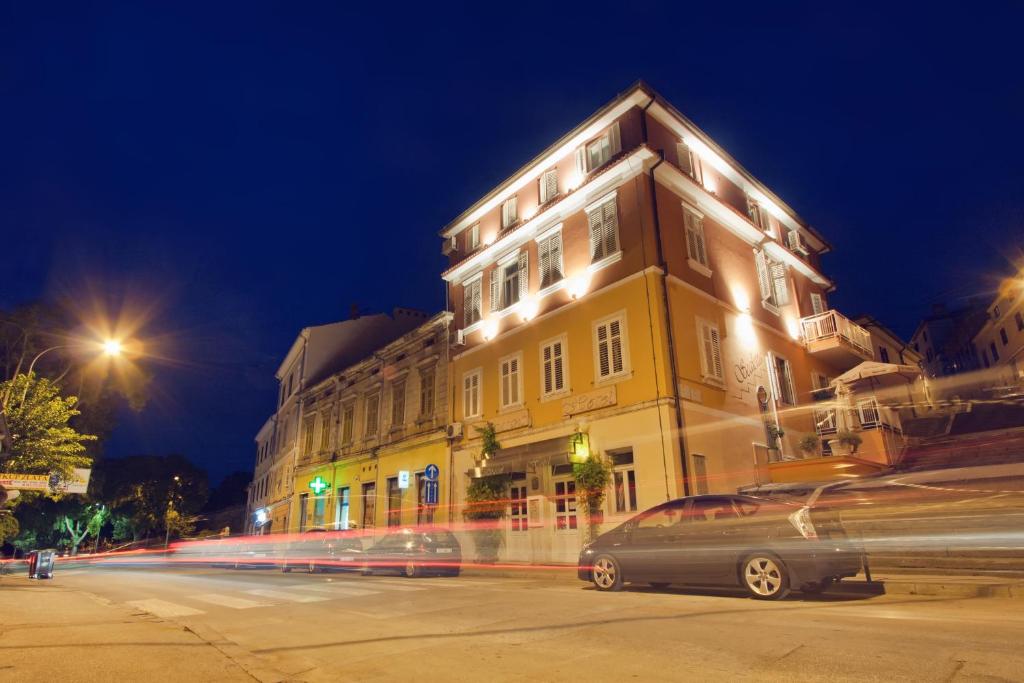 普拉斯卡勒塔酒店的一座有车在晚上驶向街道的建筑