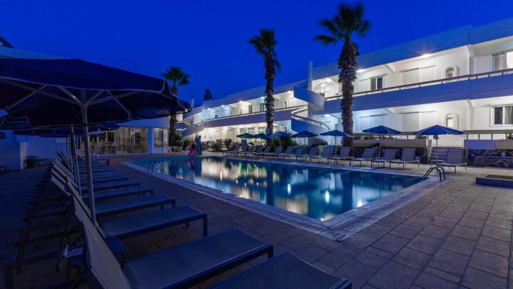 伊利索斯帕勒斯公寓酒店的一座游泳池,在晚上在建筑物前