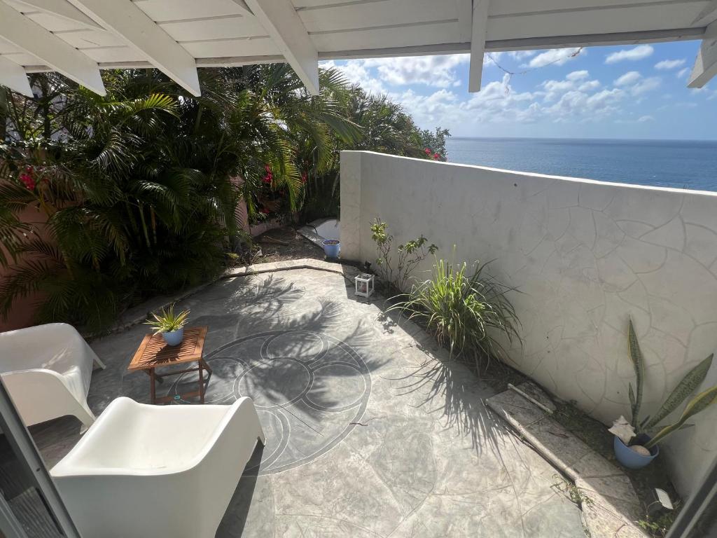 弗利盖特湾Cozzy Apartment on the Caribbean side-Frigate Bay的一个带桌椅的庭院和大海