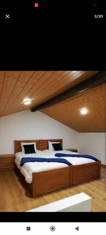 欧伦Moradias dos Castelos (Azul )的一间卧室设有一张带木制天花板的大床