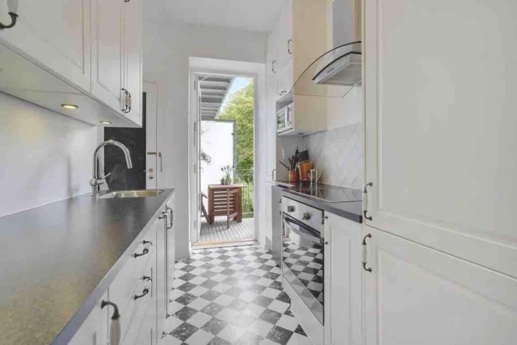 奥胡斯Cozy appartment for 2 in Aarhus的厨房配有白色橱柜和 ⁇ 格地板