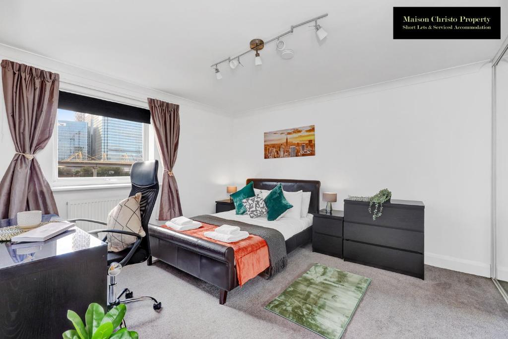 伦敦Caraway Heights 2Bedroom Apt Sleeps 6 in Canary Wharf, London with Free Parking, Wifi & Leisure By Maison Christo Property Short Lets & Serviced Accommodation的一间卧室配有一张床、一张桌子和一把椅子