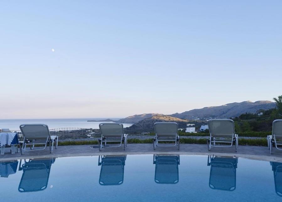 卡拉索斯Villa Lindos Star in Rodos with Private pool的一组椅子坐在游泳池旁