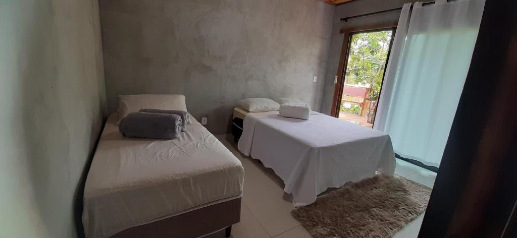 博尼图Casa das Orquídeas的小房间设有两张床和窗户