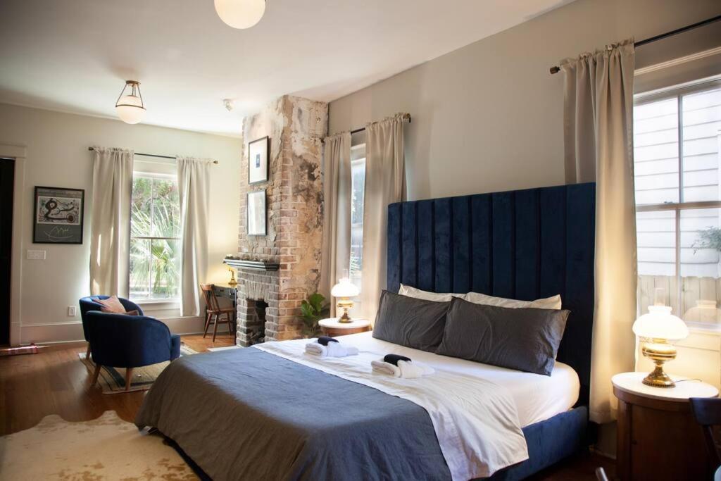 萨凡纳Intimate Library Studio - Minutes to Forsyth Park的一间卧室配有一张大床和蓝色床头板