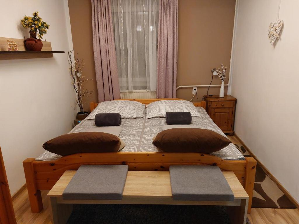 沙托劳尔尧乌伊海伊Kata Vendégház的一间卧室配有一张带两个枕头的木床