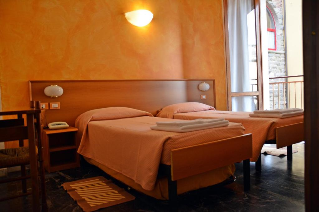 莫内利亚科拉罗酒店的橙色墙壁客房的两张床