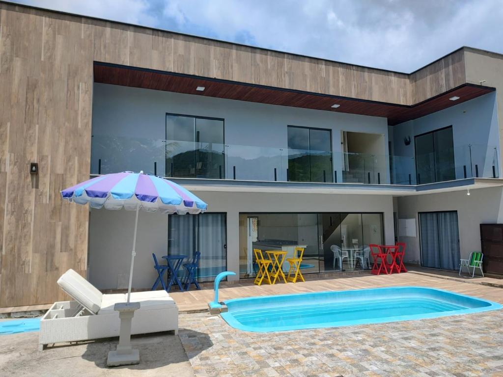 巴拉奈里奥-坎布里乌Morada Stucchi的一座带游泳池和遮阳伞的房子