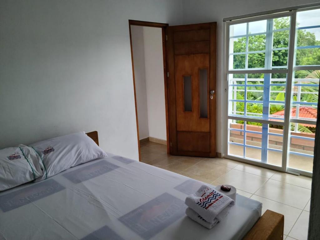 圣安特罗Olamar Hostal的一间卧室设有一张床和一个滑动玻璃门