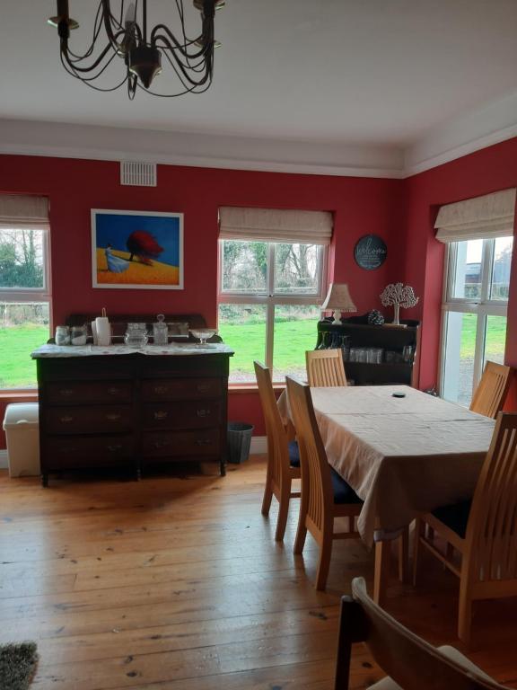 MonasterevinKYLEARD Ryan的一间拥有红色墙壁和桌椅的用餐室