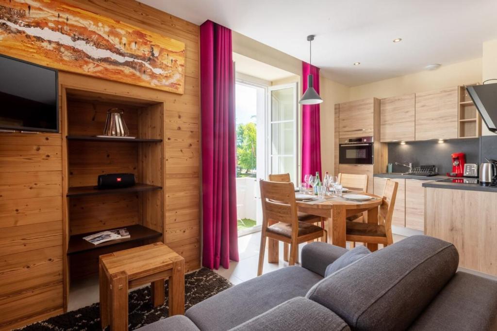 安锡CARPATES Annecy Rent Lodge的厨房以及带沙发和桌子的客厅。