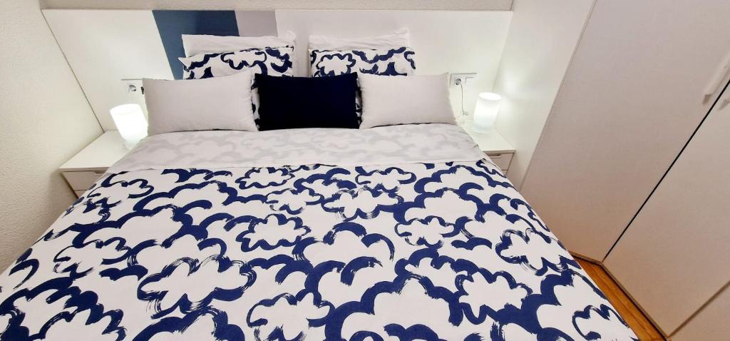 马德里Habitacion de lujo *Baño Privado* Zona Centro的一张带蓝色和白色棉被和枕头的床