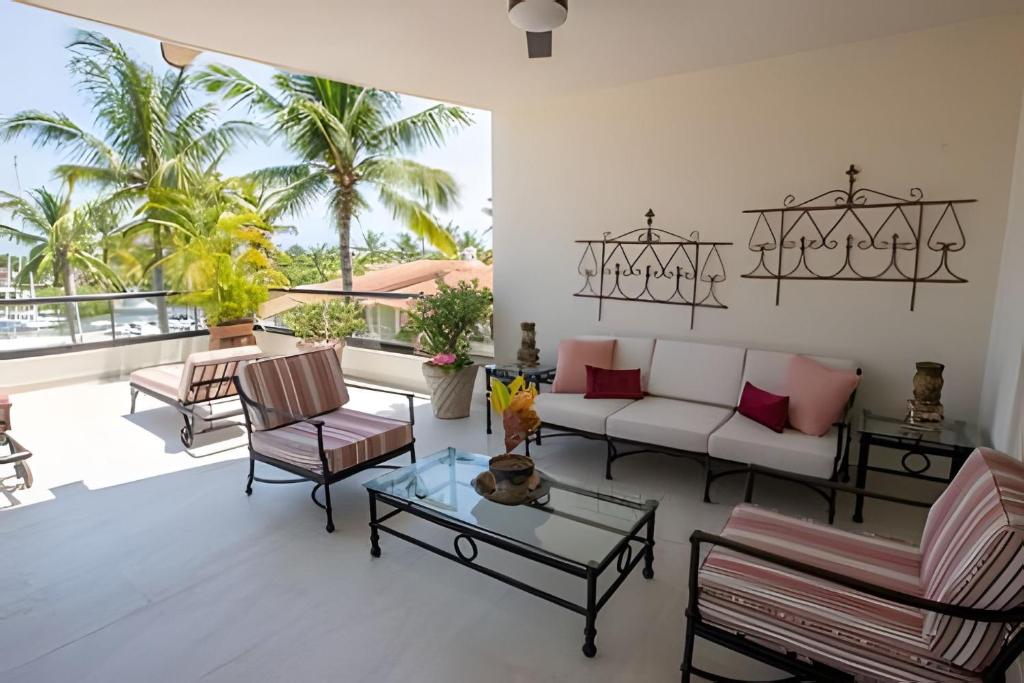 新巴利亚塔Grand Marina Villas的带沙发和椅子的客厅以及棕榈树