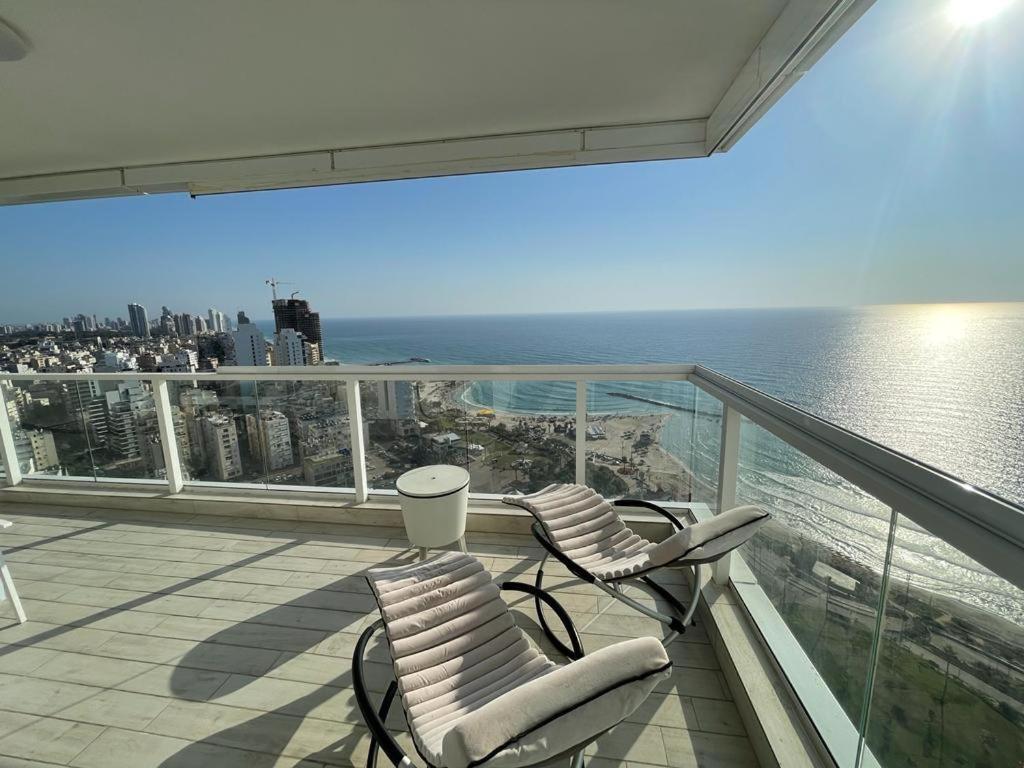 内坦亚Netanya Dream Luxury Apartment MIGDAL DAVID的阳台配有两把椅子,享有水景