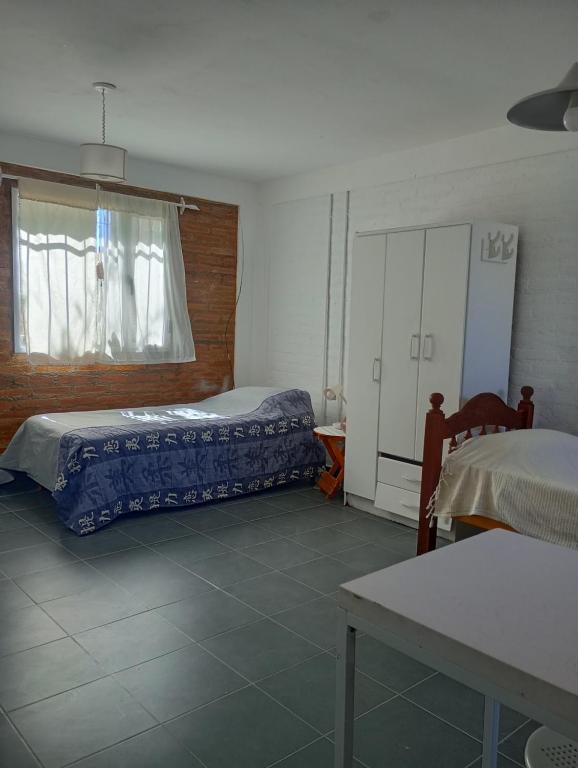 玛德琳港Pedro_Simón的一间卧室设有两张床、一个窗口和一张桌子