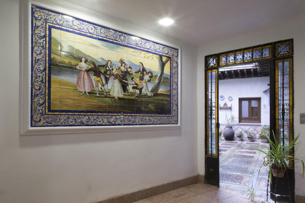 托莱多埃尔帕蒂奥德米卡萨公寓式酒店的门道旁墙上的一幅大画