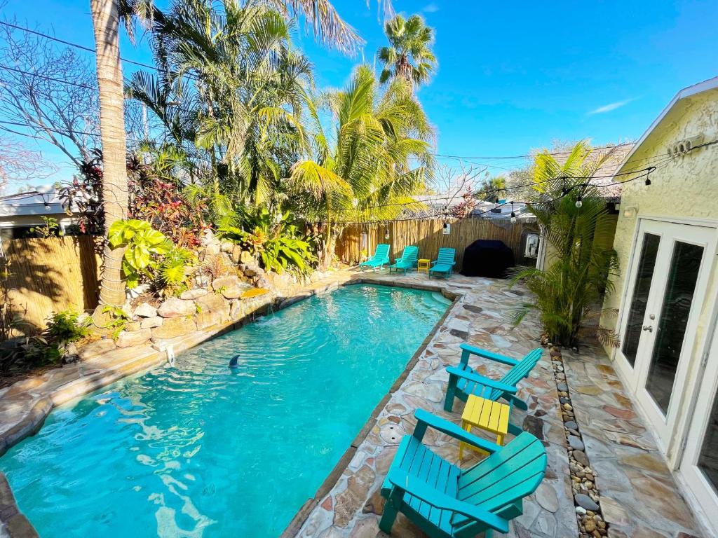 圣徒皮特海滩Laguna Azul - Sleeps 8 + Heated Pool + Walk to Beach的后院的游泳池,带蓝色椅子