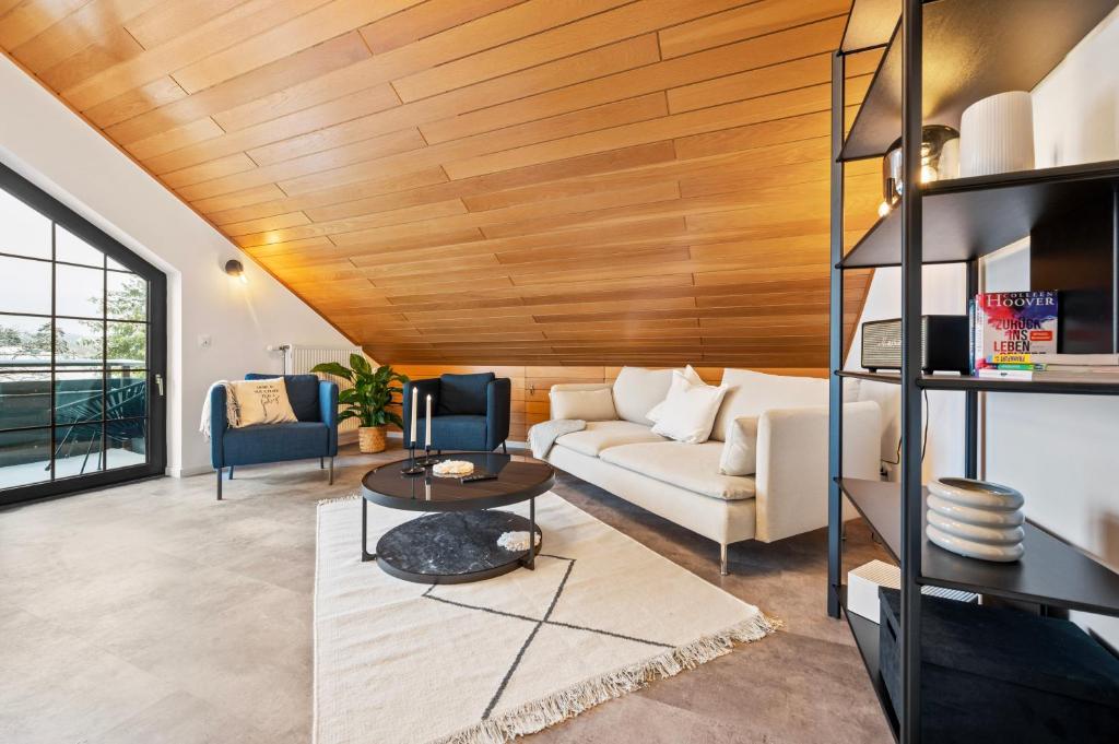 新安斯波Wohnung Weitblick的客厅设有白色沙发和木制天花板