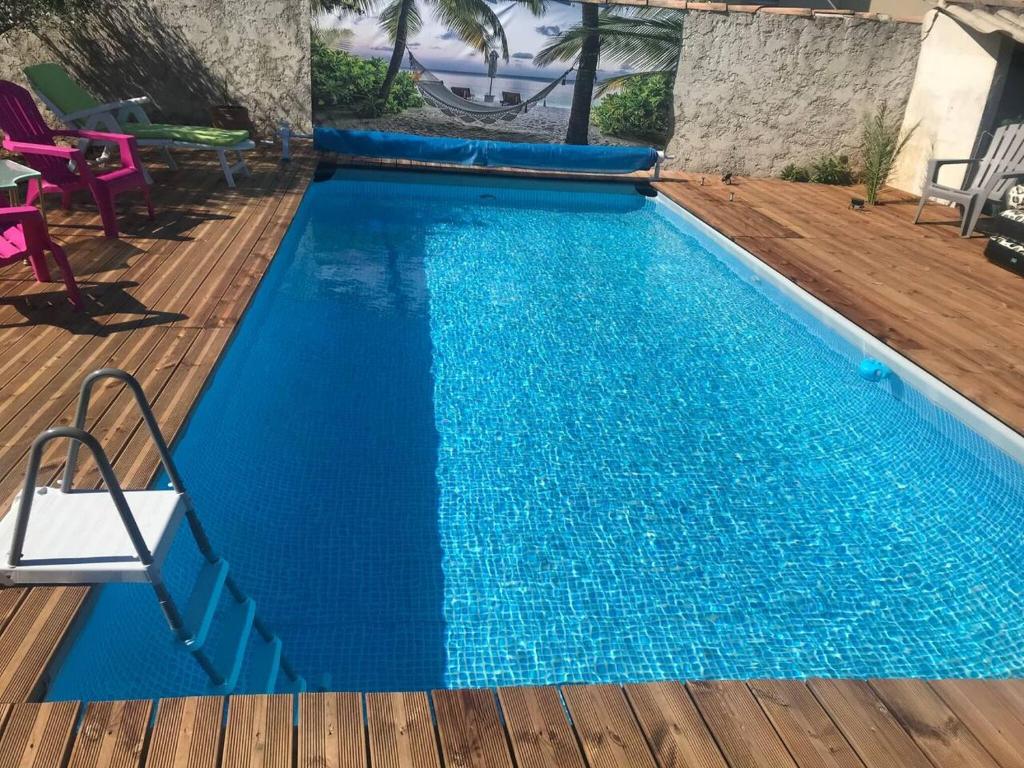 勒米伊Maison d'une chambre avec piscine partagee et wifi a Le Muy的一个带木制甲板的大型蓝色游泳池