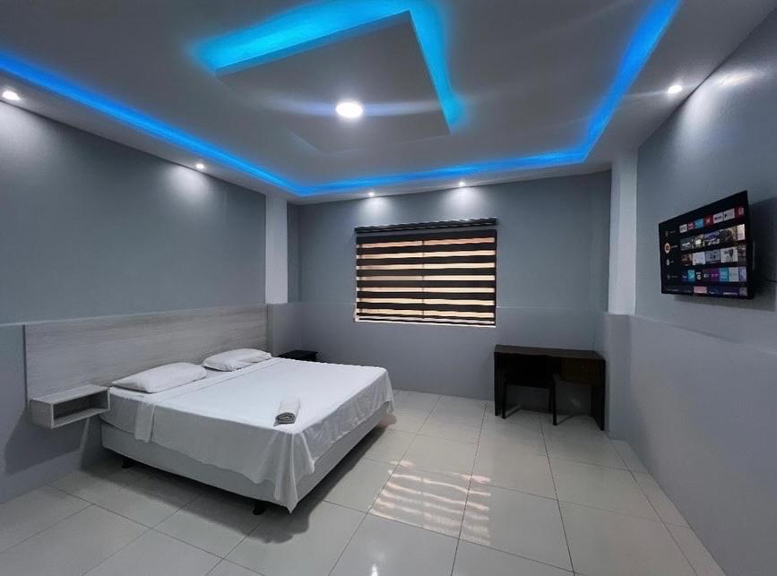 波托维耶霍Hotel KP的一间卧室设有一张天花板上蓝色灯光的床。