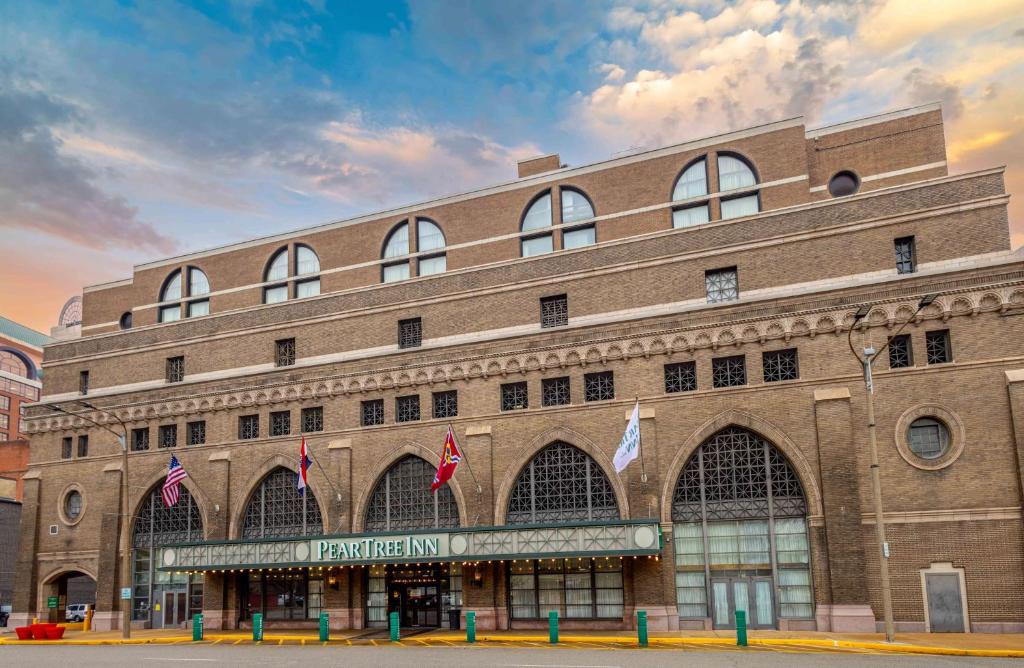 圣路易斯Pear Tree Inn St Louis Convention Center的前面有旗帜的大砖砌建筑
