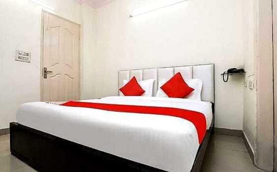 珀勒德布尔OYO Hotel Kamal的卧室配有带红色枕头的大型白色床
