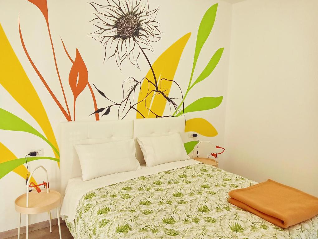 卡萨诺韦Sleep & Fly Villa Luisa的卧室配有一张挂着花壁画的床。
