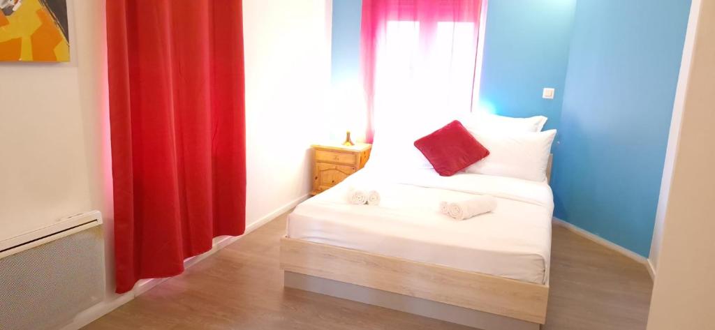 圣康坦Hôtel Le Saint Quentin的小房间,配有红色窗帘的床