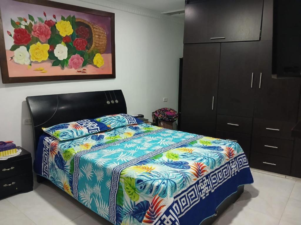 巴耶杜帕尔Alojamiento festival vallenato的一间卧室配有一张带五颜六色棉被的床