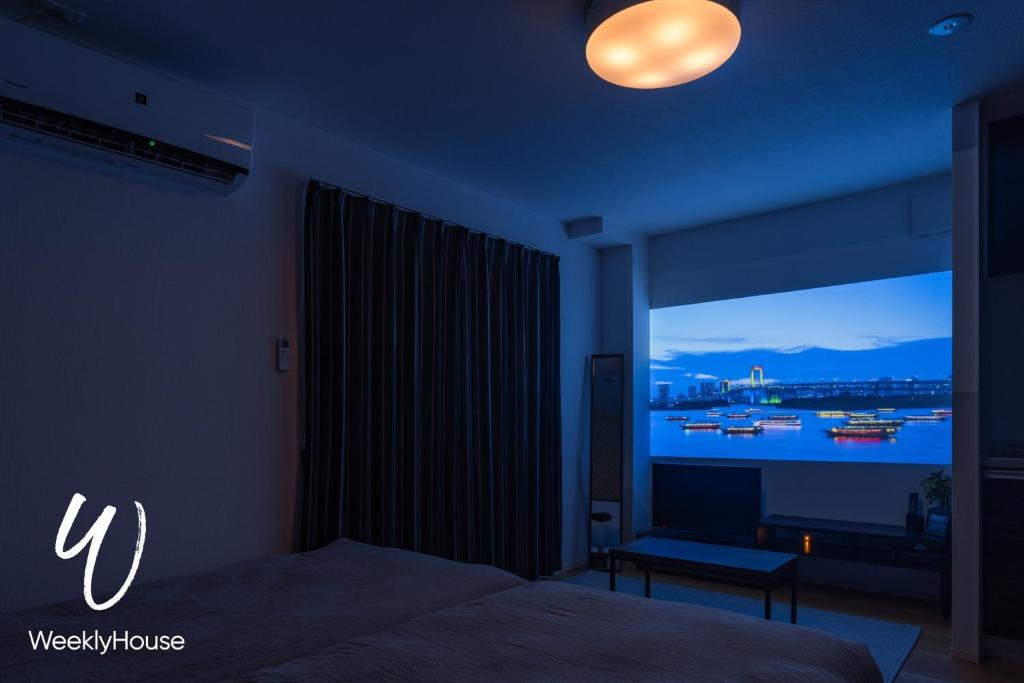 大津WeeklyHouse Silto Crete - Vacation STAY 61955v的一间卧室配有一张床,享有海港的景色
