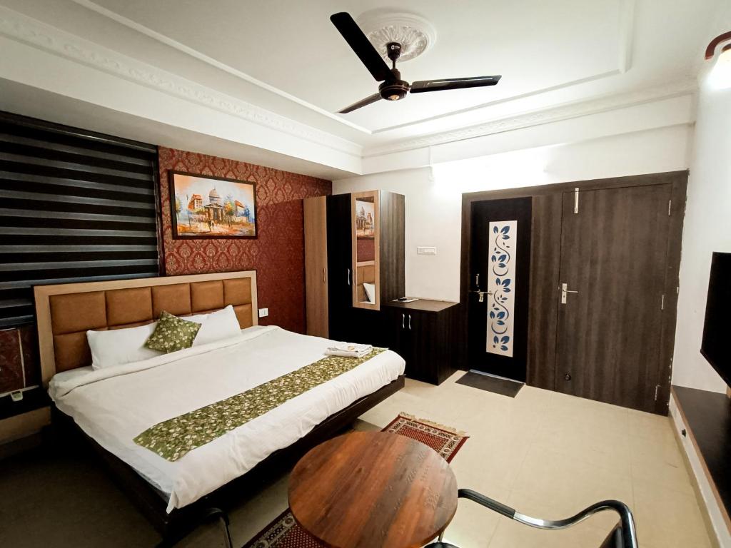 兰奇StayVilla Royal Executive Rooms的一间卧室配有一张床和一张木桌