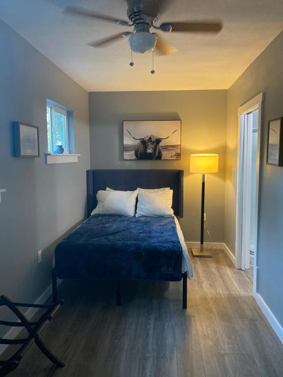 奥斯汀ATX Tiny House的一间卧室配有一张蓝色的床和吊扇