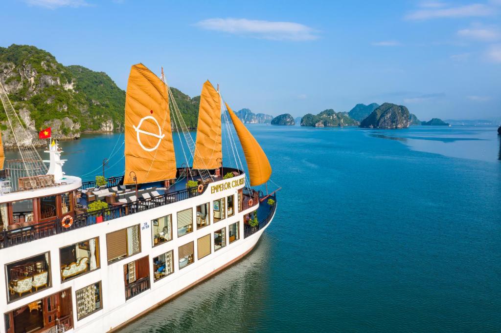 下龙湾Emperor Cruises Legacy Ha Long的一艘船在水中,背景是群山