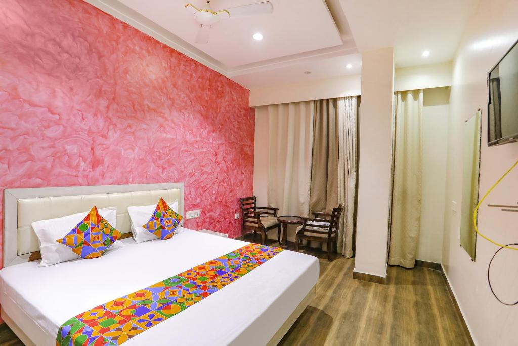 坎普尔FabHotel Uday Villa的一间卧室配有一张床和粉红色的墙壁