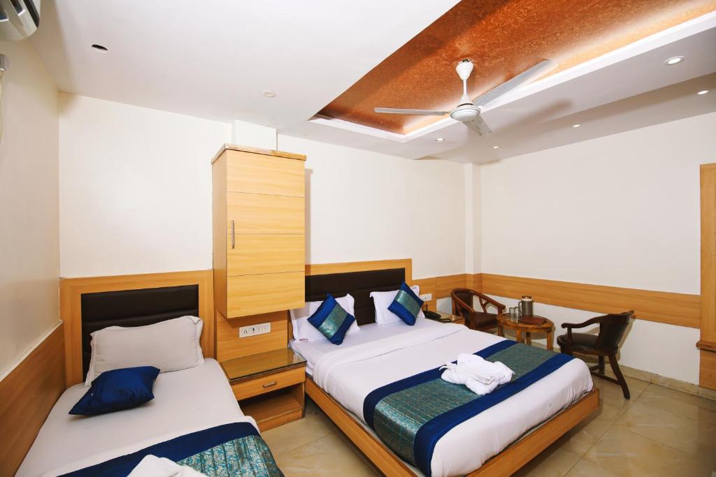 新德里Hotel Lav-Kush的一间卧室配有两张床和吊扇