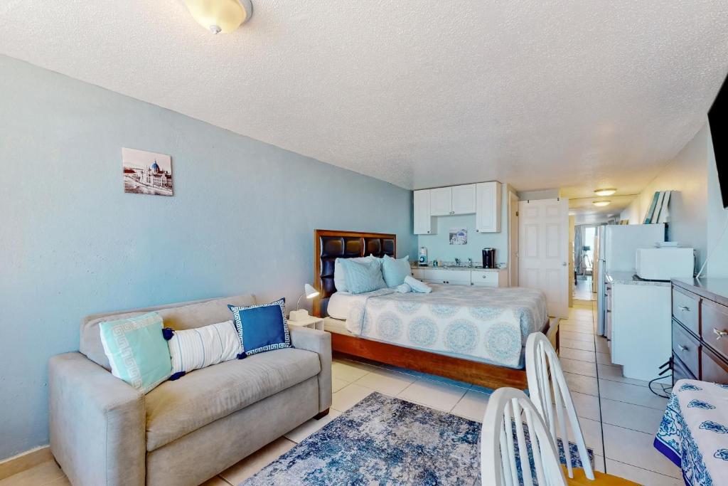 代托纳海滩Pirates Cove Unit G22的一间卧室配有一张床和一张沙发,还设有一间厨房
