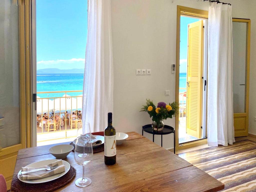 爱琴娜岛Port view apartment Aegina的木桌上的一瓶葡萄酒,享有海景