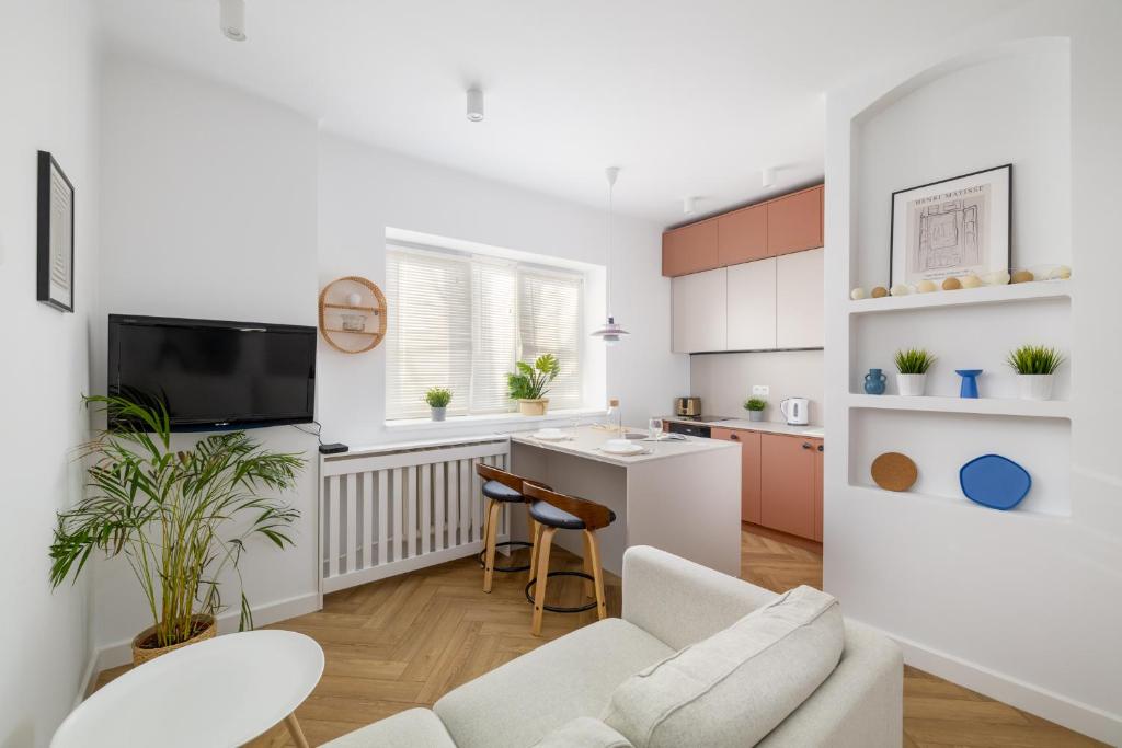 华沙ECRU Design Apartment in City Center WWA46的厨房以及带沙发和桌子的客厅。