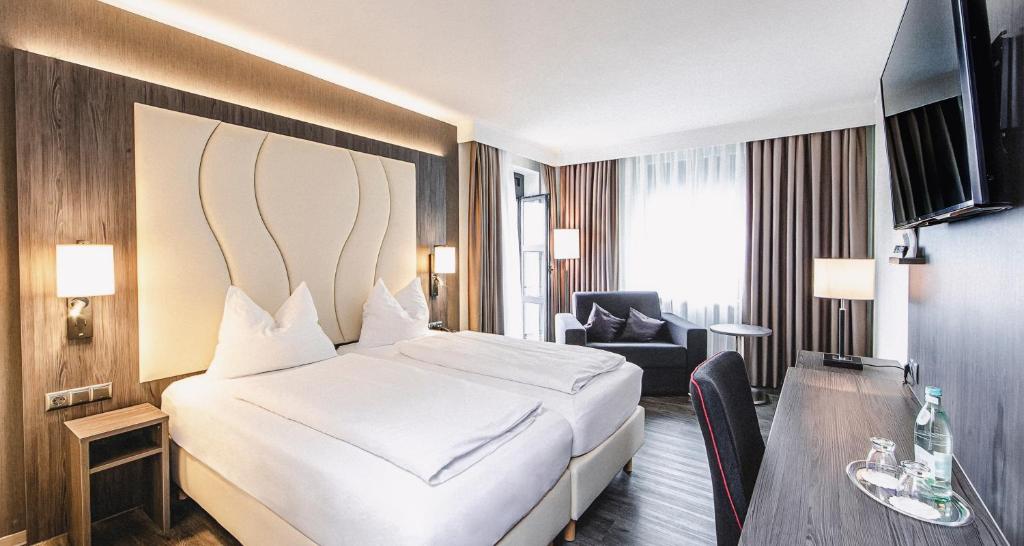 腓特烈港布奇霍尔内霍夫广场酒店的一间酒店客房,配有一张白色的床和一张书桌