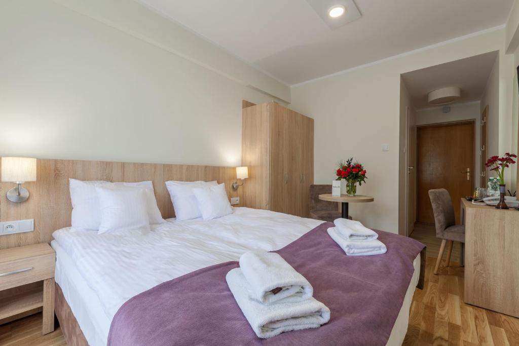 克雷尼察Silesia Krynica的一间卧室配有一张大床和毛巾
