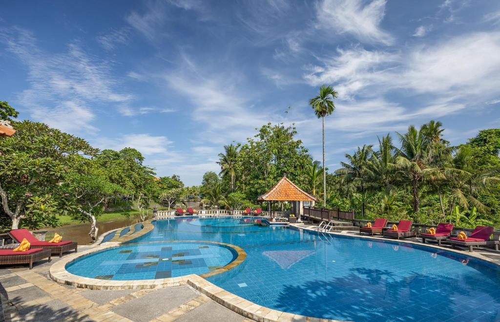 苏卡瓦提圣曼陀罗别墅及温泉酒店的一个带椅子和树木的度假村游泳池