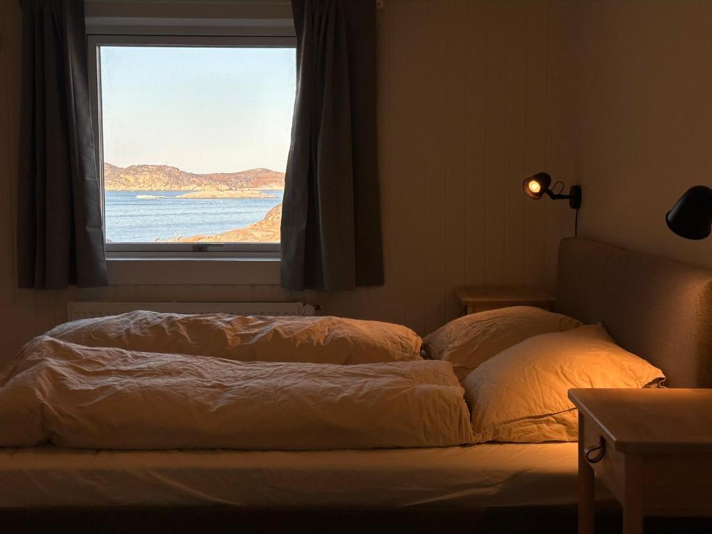 伊卢利萨特Grand seaview vacation house, Ilulissat的窗户客房内的一张床位