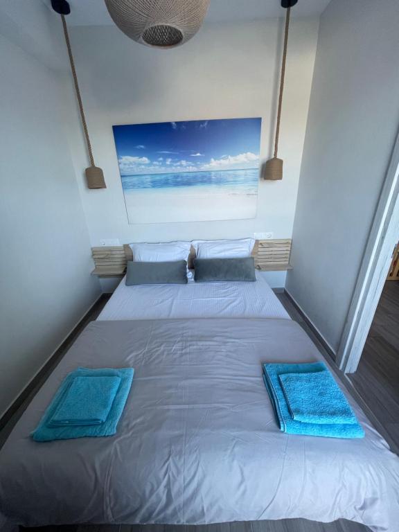 萨索斯Dukas Apartment的一张位于房间的床,上面有两个蓝色的枕头